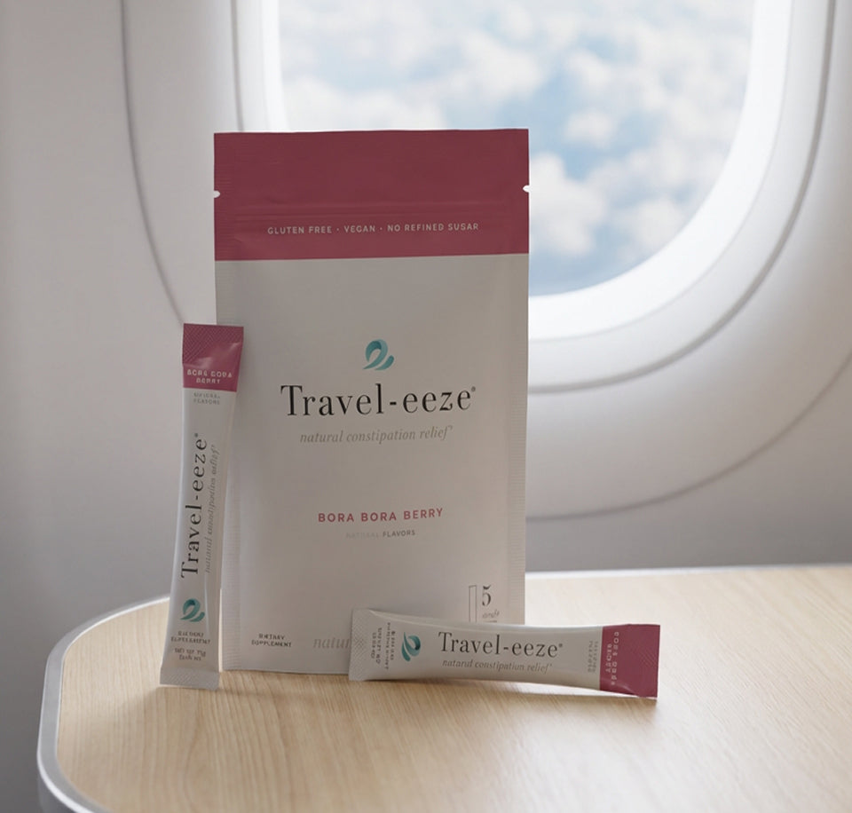 Travel-eeze product packaging on a plane tray table with airplane window in the background