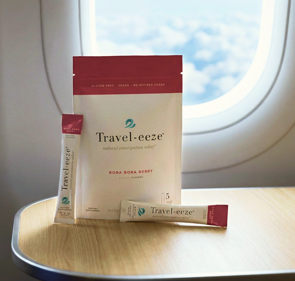 Travel-eeze product packaging on a plane tray table with airplane window in the background